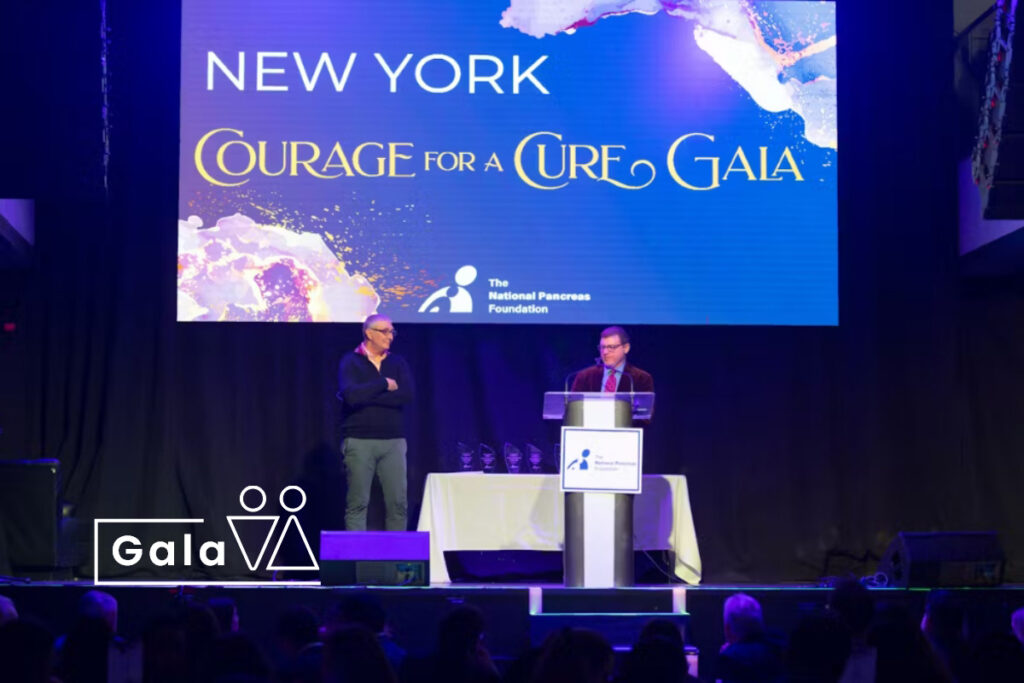 Gala presentation on stage with guests seated at HK Hall
